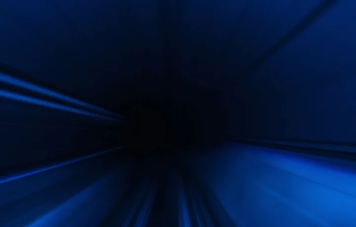 Blue light streaking outward from a dark centre, motion-blurred.