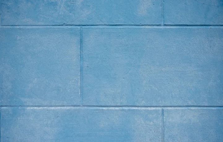 A plain blue-painted block wall, courses running edge to edge.